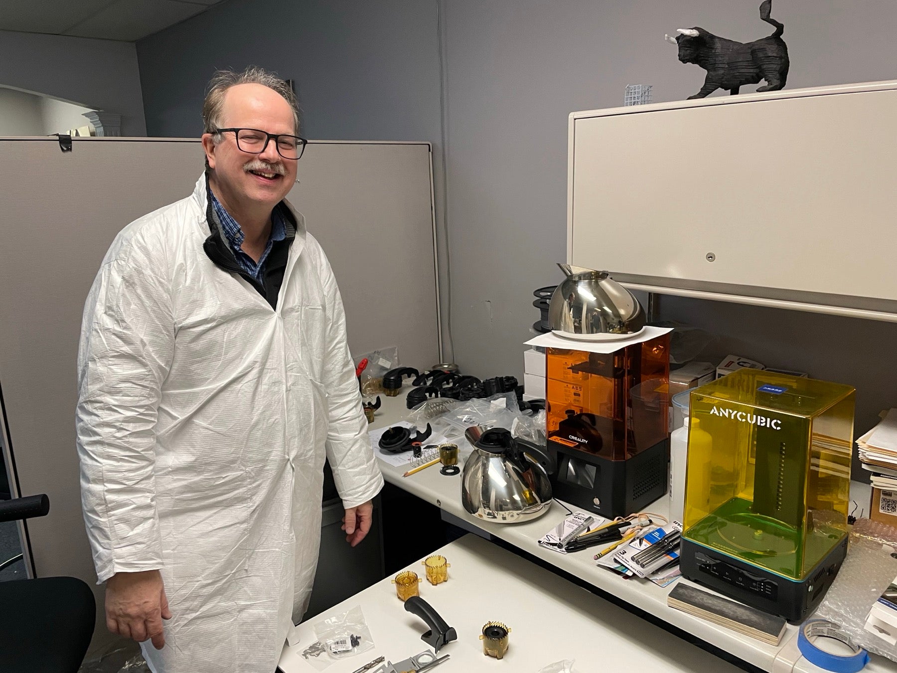 Tom Pierce standing beside Musical Tea Kettle prototypes and 3D printers